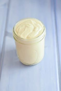 a jar filled with cream sitting on top of a blue table