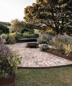 a brick patio surrounded by plants and trees