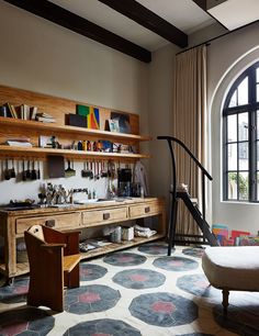 a living room filled with furniture and a large window next to a wall mounted shelf