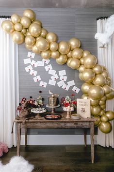 a table topped with lots of gold balloons