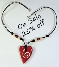 A perfect one-of-a-kind gift for yourself or someone special such as your mother, daughter, grandmother, wife, or friend. Especially for lovers of handmade ceramic jewelry. This elegant hand-crafted ceramic necklace has a glazed porcelain pendant that is 2 1/4"x1 1/2". It is strung on a black leather cord.  The closure is a sterling silver hook and loop.  The necklace is 20" long.  Other materials include wood and glass beads. This unique jewelry piece is the perfect accessory for daytime or evening wear. NOTE: Ceramic necklaces may be breakable if dropped on a hard surface. Each pendant is hand made by me using molds I have created or natural textures. Every artisan created piece has differences or imperfections which make it unique.  If you have any questions, please don't hesitate to as Handmade Polymer Clay Beaded Necklaces For Gifts, Adjustable Beaded Necklaces In Polymer Clay As A Gift, Adjustable Polymer Clay Beaded Necklace For Gifts, Adjustable Beaded Polymer Clay Necklaces For Gifts, Handmade Spiral Beaded Necklace As Gift, Heart Beads Polymer Clay Jewelry Gift, Ceramic Necklaces, Ceramic Pendant Necklace, Handmade Ceramic Jewelry