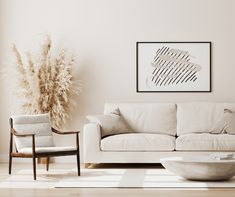 a living room with a white couch, chair and vase on the floor in front of it