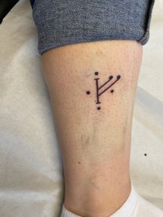 a person with a tattoo on their leg that has the letter y in small dots