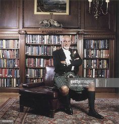 a man in a kilt sitting on a chair