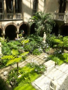 a courtyard with many plants and statues in it