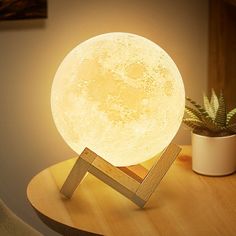 the moon lamp is sitting on top of a table