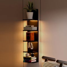 a room with a chair, bookshelf and plant on the wall next to it