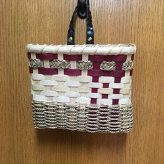 a woven purse hanging on a wooden door