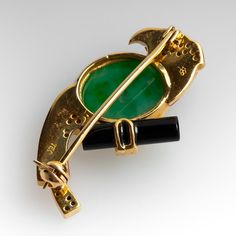 The brooch features a bird motif and is accented with one (1), bezel set, oval cabochon cut natural jadeite jade, thirty (30), bead set, round brilliant cut diamonds, one (1), bezel set, round mixed cut natural ruby and custom cut pierced of coral and black onyx. The brooch measures 30.0mm X 17.0mm and is finished with a pin stem and safety catch. Bird Pins, Bird Motif, Bead Set, Emerald Jewelry, Natural Ruby, Brilliant Diamond, Oval Cabochon, Round Brilliant Cut Diamond, High Quality Jewelry