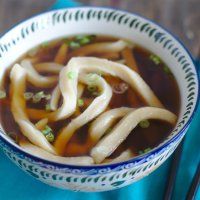 a close up of a bowl of soup with noodles