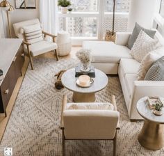 a living room filled with white furniture and lots of windows