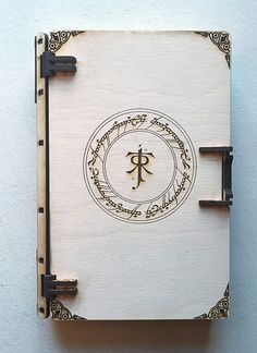 a wooden box with an ornate design on the front and sides, sitting against a white wall