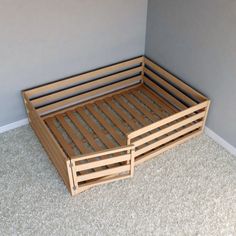 a wooden bed frame sitting on top of a carpeted floor next to a wall