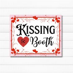 a red and white sign that says kissing booth with hearts in the center on it