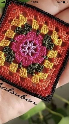 a hand holding a small square with a flower on it's center and the words, crochet together