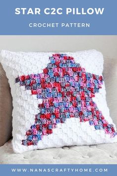 a crochet star pillow sitting on top of a white couch next to a window