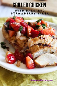 grilled chicken with balsamic strawberry salsa on a white plate next to sliced strawberries