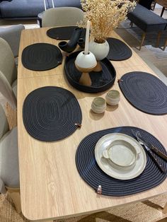 a wooden table topped with plates and cups