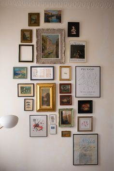 a wall with many framed pictures on it