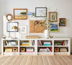 a white shelf with books and pictures on it