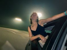 a woman leaning out the window of a car