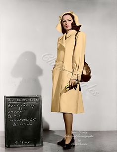 an old fashion photo of a woman in a trench coat standing next to a chalkboard