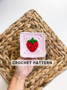 a hand holding up a crocheted strawberry square with the words crochet pattern on it