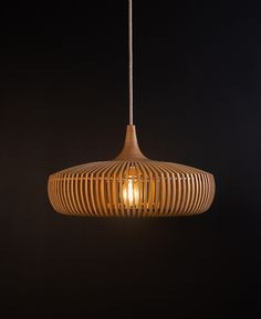 a wooden light fixture hanging from a ceiling in a dark room with no lighting on it