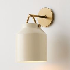 a white wall light mounted on the side of a wall next to a lamp shade