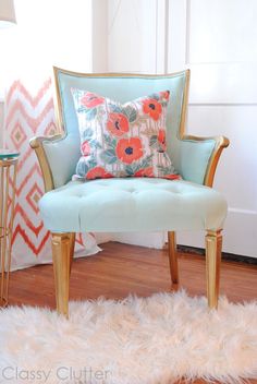 a blue chair sitting on top of a hard wood floor next to a white rug