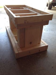 a wooden table sitting on top of a hard wood floor next to a white truck