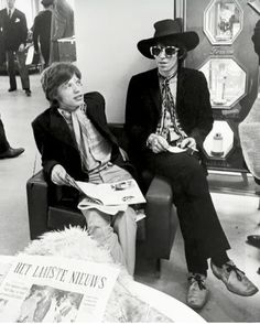 black and white photograph of two men in hats sitting next to each other