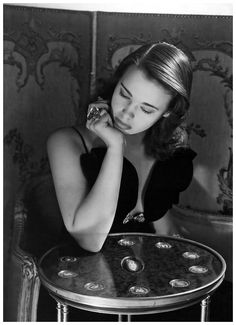 a woman sitting at a table with her hands on her face