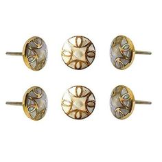 four pairs of gold and mother of pearl studs, each with an intricate design