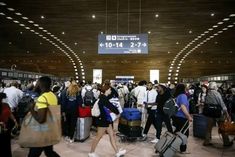 many people are walking through an airport with their suitcases and luggage bags in hand