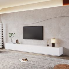 a large flat screen tv mounted on the wall above a white entertainment center in a living room