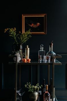 a bar cart with bottles and glasses on it