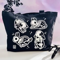 The perfect cute accessory for your everyday needs! Crafted from durable 12oz cotton canvas with a convenient zipper closure, the bag features original art from Ika Ink of 4 little skeleton bunnies (skelebuns!) in a sky of stars. It makes for the perfect Halloween accessory to complete your spooky ensemble or casual bag for every day use for those who like to live a little on the dark side of things.  Measuring 16 inches in long, 13 inches in height with a 4 inch gusset and 22 inch fabric handle Novelty Pouch Bags For Everyday Use, Black Novelty Bag For Everyday Use, Skeleton Bunny, Screen Printed Bags, Iridescent Material, Space Bunnies, Eco Friendly Shopping Bags, Tote Bag With Zipper, Washi Tape Planner