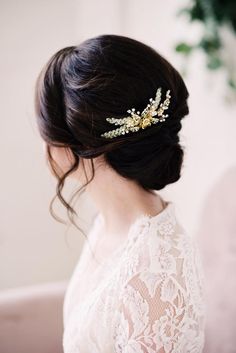 a woman wearing a wedding hair comb with gold leaves on it's head, in front of a white background