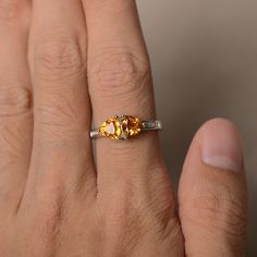 a woman's hand with a yellow and white diamond ring