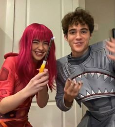 two people dressed up in costumes and one is holding a toothbrush while the other holds a cell phone