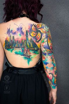 the back of a woman's body with tattoos on her upper and lower half