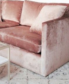 a pink couch sitting on top of a white rug