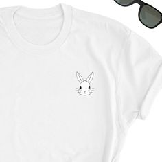 Bunny Rabbit Cute Shirt, Funny Bunny Shirt, Cute Rabbit Lover shirt, Rabbit Love T-shirt, Bunny Tee, Rabbit Face Tee, Rabbit UNISEX Shirt Love Rabbits? Who doesn't? Take this Rabbit icon design by your side everywhere. Friends will love it! This t-shirt feels soft and lightweight, with the right amount of stretch. It's comfortable and flattering for both men and women. * 100% cotton (heather colors contain polyester) * Fabric weight: 5 oz * Shoulder-to-shoulder taping * Side-seamed Time for Deli Cute White Screen Print Top, Cute White Crew Neck Shirt, Cute White Print Crew Neck Top, Rabbit Icon, Rabbit Face, Cat Dad Shirt, Sloth Shirt, Rabbit Lover, Funny Bunny