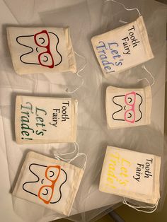 four tea bags that have been decorated with words and masks on them, sitting on a table