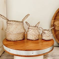 three woven baskets sitting on top of a wooden table