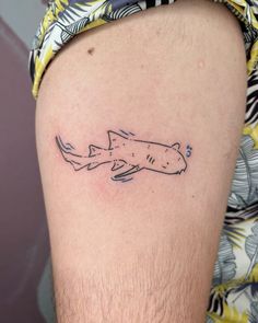 a man's arm with a tattoo of a shark on the back of his leg