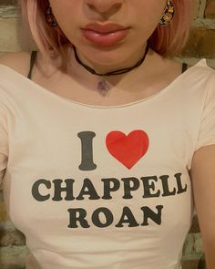 a woman with pink hair wearing a t - shirt that says i love chapell ron