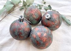 four ornaments are sitting on a white cloth