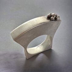 Graceful and elegant "hollow form" can be thought of as a small sculpture to wear! Amazingly comfortable as it follows the curvature of your fingers with its curvy contours. In sterling silver with a lovely satin brushed texture applied by hand, this is truly a beautiful piece of contemporary art to wear! This ring is 1/4" in width and measures 1 1/4" from top to bottom with approximately 3/8" of that sitting above the top of your finger. It measures to be approximately a 7 3/4 women's size ring Modern Silver Dome Ring For Wedding, Elegant Handmade Silver Dome Ring, Contemporary Sculptural Silver Jewelry, Contemporary Silver Ring With Unique Design, Contemporary Silver Rings For Wedding, Elegant Silver Dome Ring With Concave Shape, Formal Sculptural Silver Jewelry, Modern Silver Pearl Ring For Gifting, Modern Silver Pearl Ring With Polished Finish